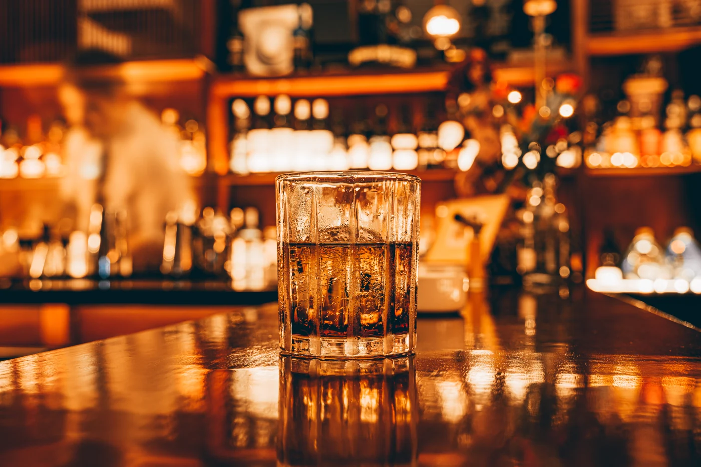 吧台暖光下的威士忌杯